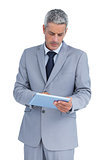 Frowning businessman using tablet pc