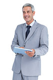 Happy businessman using tablet pc looking away