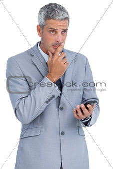 Worried businessman holding his cellphone