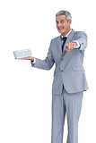Good looking businessman offering gift and pointing at camera