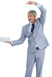 Funny businessman holding gift in right hand