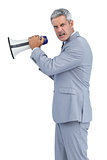 Furious businessman posing with loudspeaker