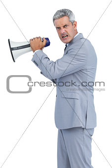 Furious businessman posing with loudspeaker