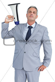Businessman posing with loudspeaker on his shoulder