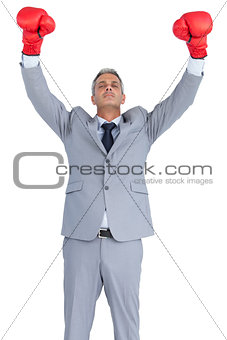 Cocky businessman posing with red boxing gloves