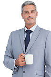 Confident businessman standing with coffee