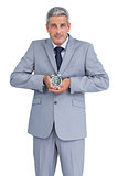 Businessman with alarm clock in both hands