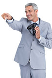 Businessman holding binoculars and pointing out something