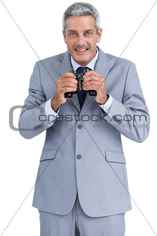 Businessman holding binoculars in both hands