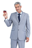 Handsome businessman showing credit card