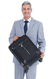 Smiling handsome businessman carrying suitcase