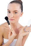 Sensual model with powder compact and brush