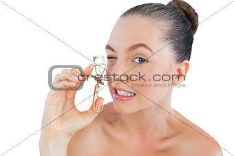 Pretty woman curling her eyelashes