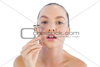 Sexy woman curling her eyelashes
