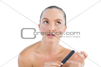 Thoughtful brunette with nail file