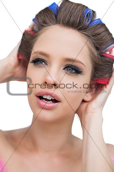 Model with hair curlers touching her hair