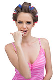 Model wearing hair curlers biting her finger sexily