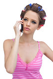 Thoughtful model in hair rollers on the phone