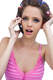 Sexy young model wearing hair rollers with phone