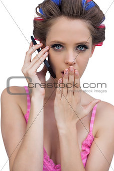 Secretive model wearing hair rollers with phone