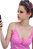 Model wearing hair rollers posing looking at the phone