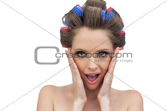 Astonished model in hair rollers posing