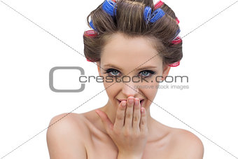 Secretive lady in hair rollers posing looking at camera
