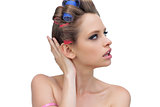 Pensive lady posing with hair curlers