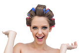 Cheerful model posing with hair curlers