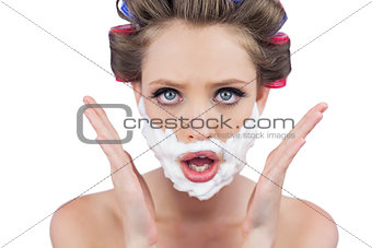 Astonished woman posing with shaving foam on face