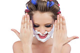 Pensive woman with hands up and shaving foam on face