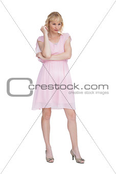 Stern blonde in pink dress posing