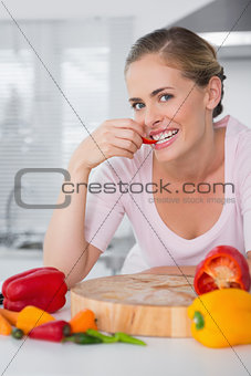 Attractive woman posing while eating vegetables