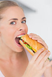 Happy woman eating sandwich