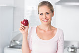 Cheerful woman holding apple in right hand