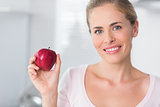 Smiling woman holding apple in right hand
