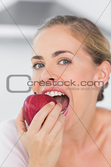 Attractive woman munching red apple