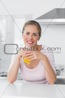 Cheerful blonde woman having orange juice