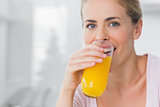 Cheerful woman drinking orange juice