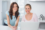 Cheerful women using laptop together