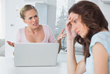 Unhappy woman thinking while her friend is getting angry at her