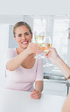 Radiant women holding glasses of white wine