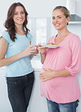 Smiling pregnant woman and her friend