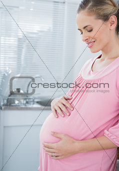 Expecting woman affectionately touching her belly