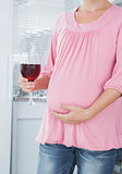 Expecting woman with glass of red wine