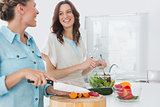 Cheerful women preparing salad together