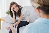 Worried woman sitting and looking at camera during therapy