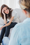 Upset woman sitting and looking at camera during therapy