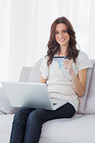 Woman shopping online and smiling at camera