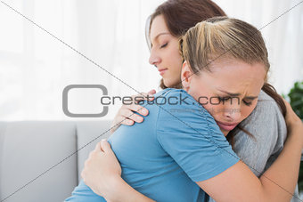 Woman taking her friend in her arms